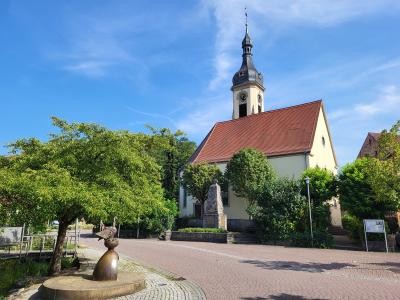 Dorfplatz in Schatthausen mit Evangelischer Kirche und Gänsebrunnen.