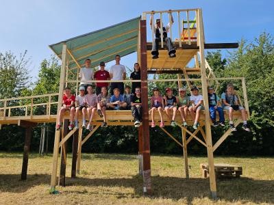 Kinder und Betreuende arbeiten gemeinsam auf der Kinderbaustelle.