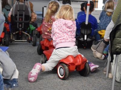 Autokino-Nachmittag: Kinder sitzen auf Bobbycars und Kettcars.