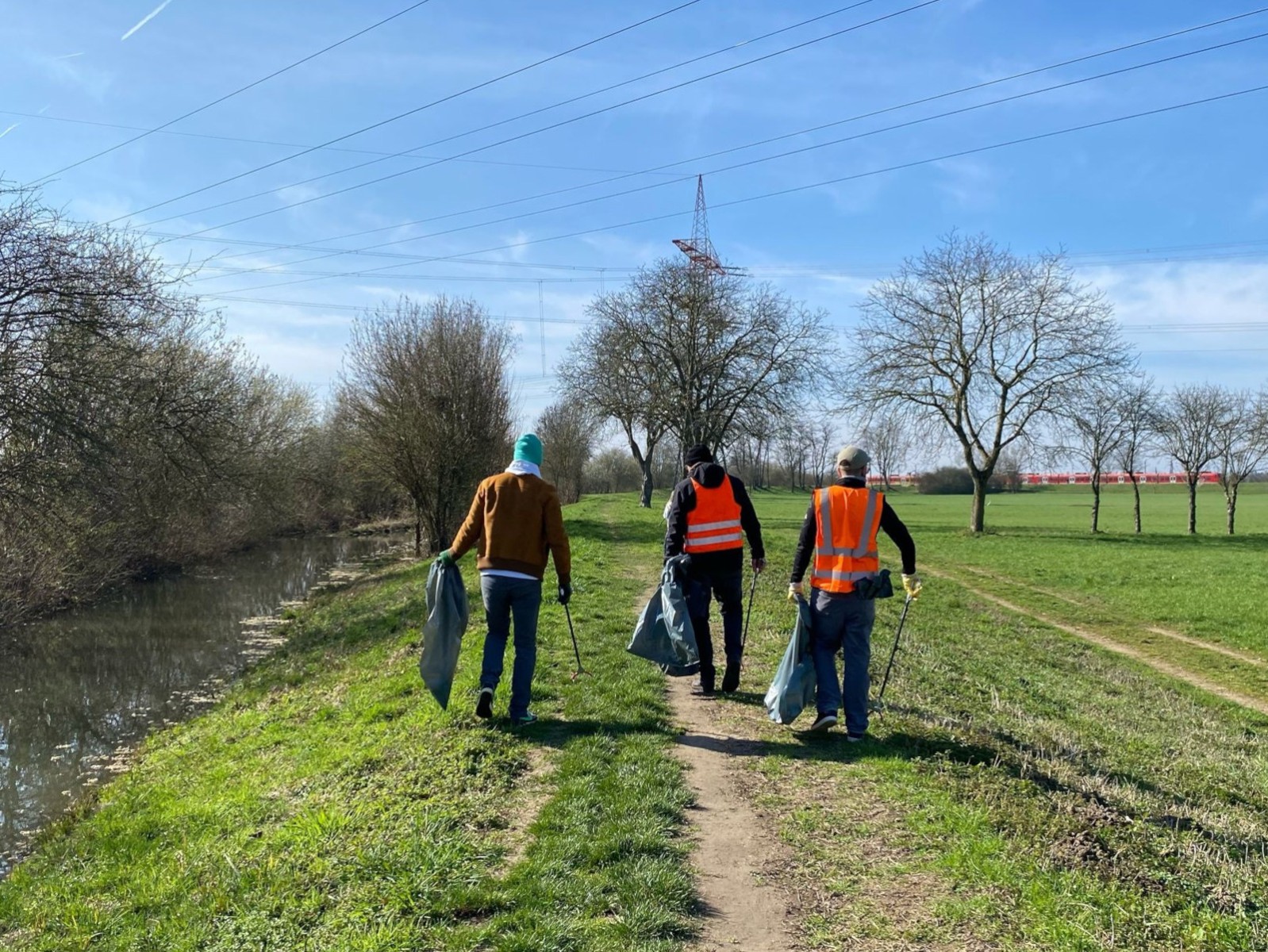 Menschen sammeln Müll entlang einem Leimbach-Spaazierweg.