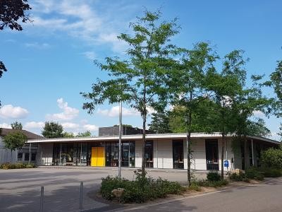 Schulgebäude mit davorliegendem Schulhof.