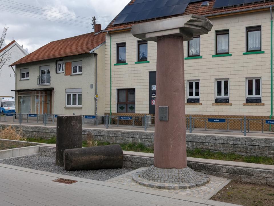 Eingangssäule der ehemaligen Synagoge mit aus Edelstahl nachgebildetem Bruchstück des Kapitells.