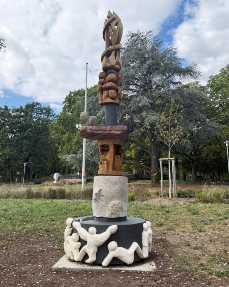 Schlanke, aufrechte Skulptur aus verschiedenen Materialien zusammengesetzt.
