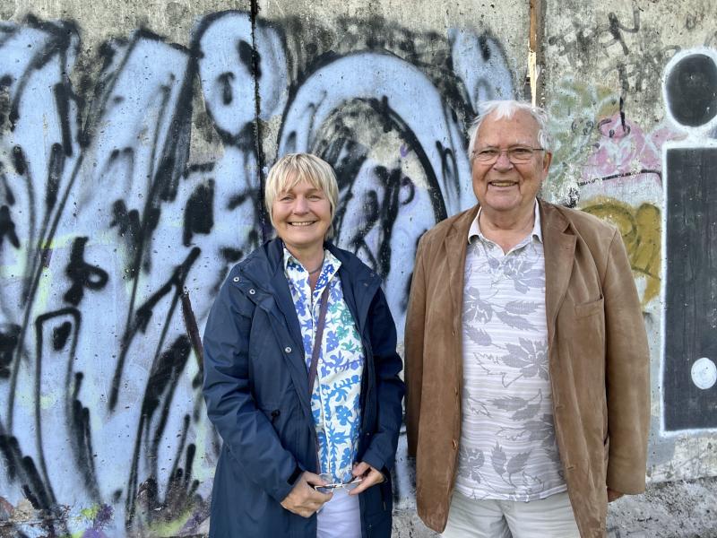 Maja Nielsen und Joachim Neumann vor einem Stück der Berliner Mauer.