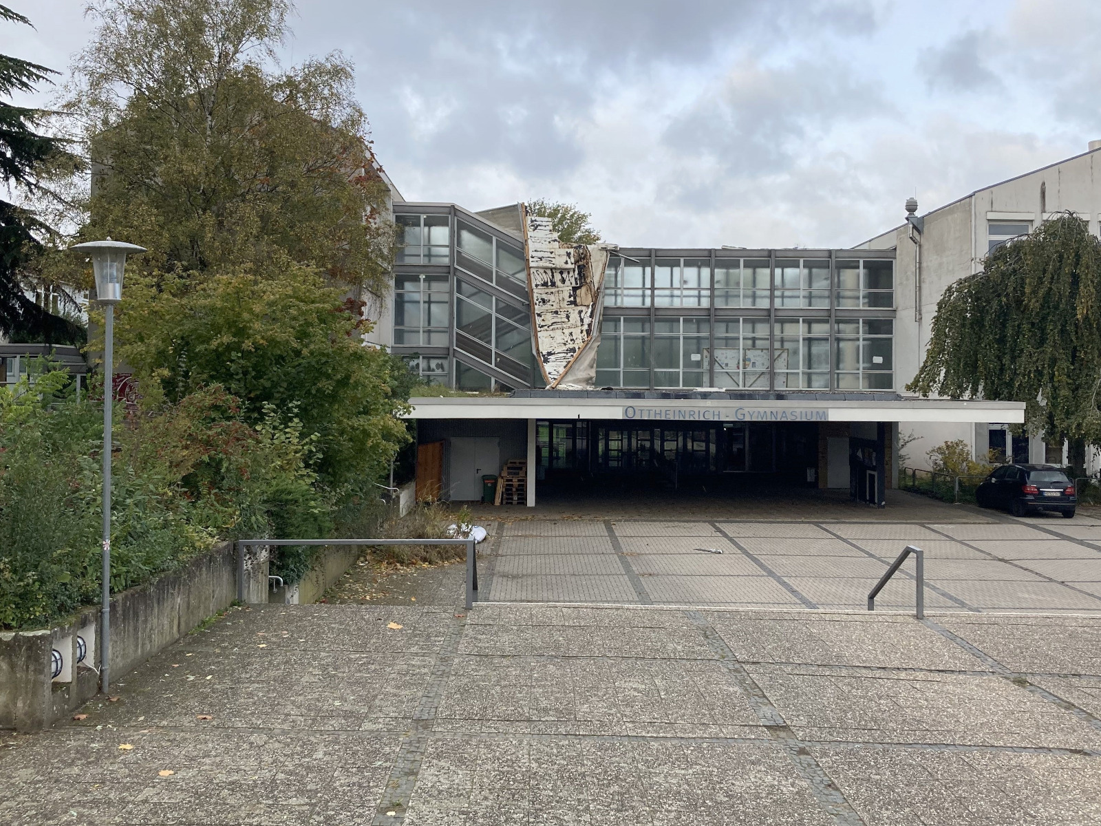 Haupteingang des Gebäudes mit durch einen Sturm zerstörter Dachabdeckung. Haupteingang des Gebäudes mit durch einen Sturm zerstörter Dachabdeckung.