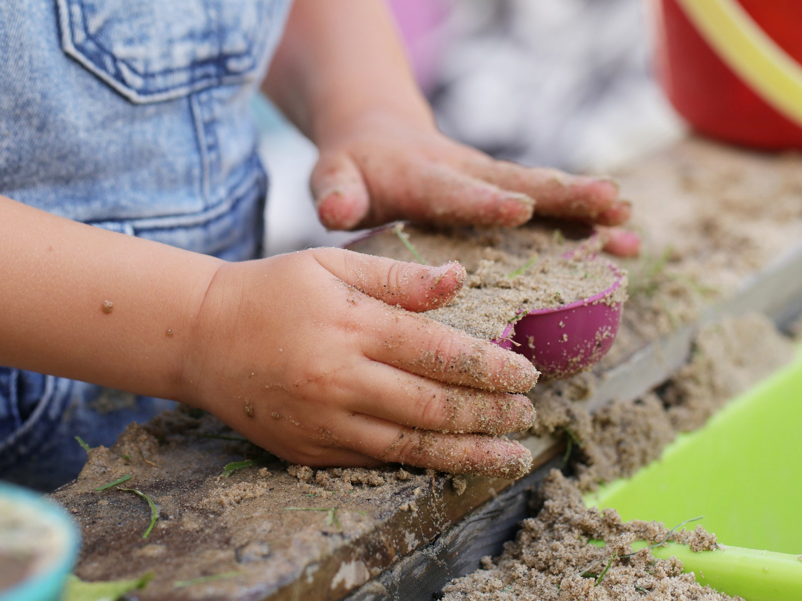Ein Kind spielt im Sandkasten.