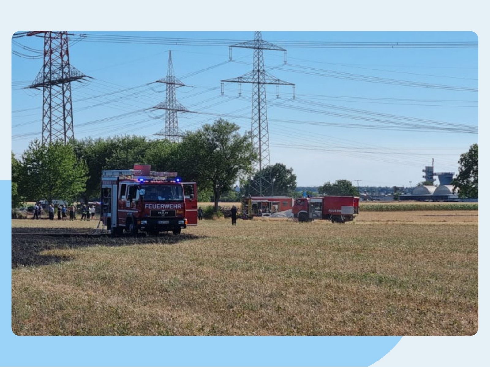 Feuerwehrautos stehen auf einem abgeernteten Feld.
