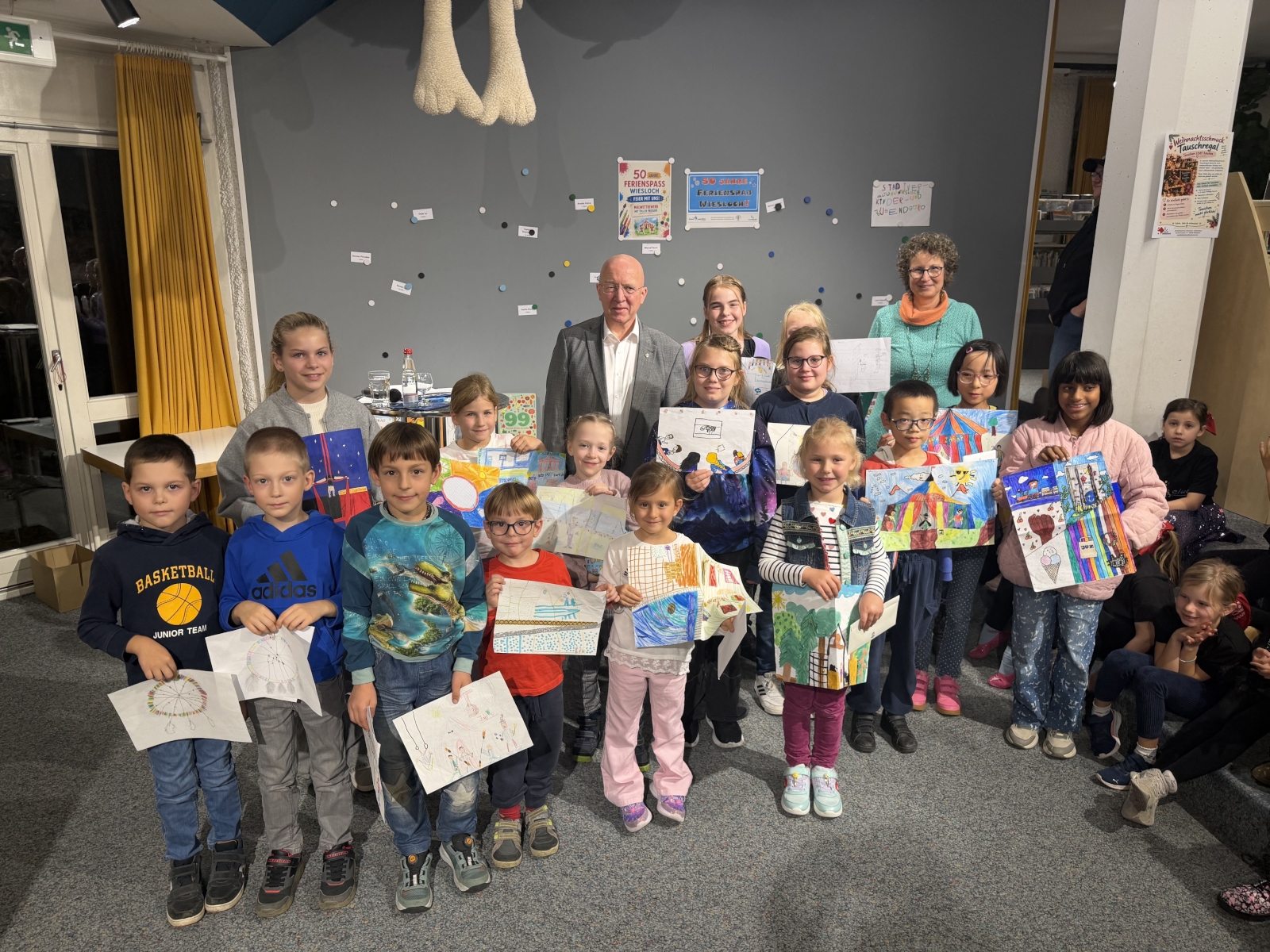 Gruppenfoto der ausgezeichneten Kinder, die ihre gemalten Bilder halten.