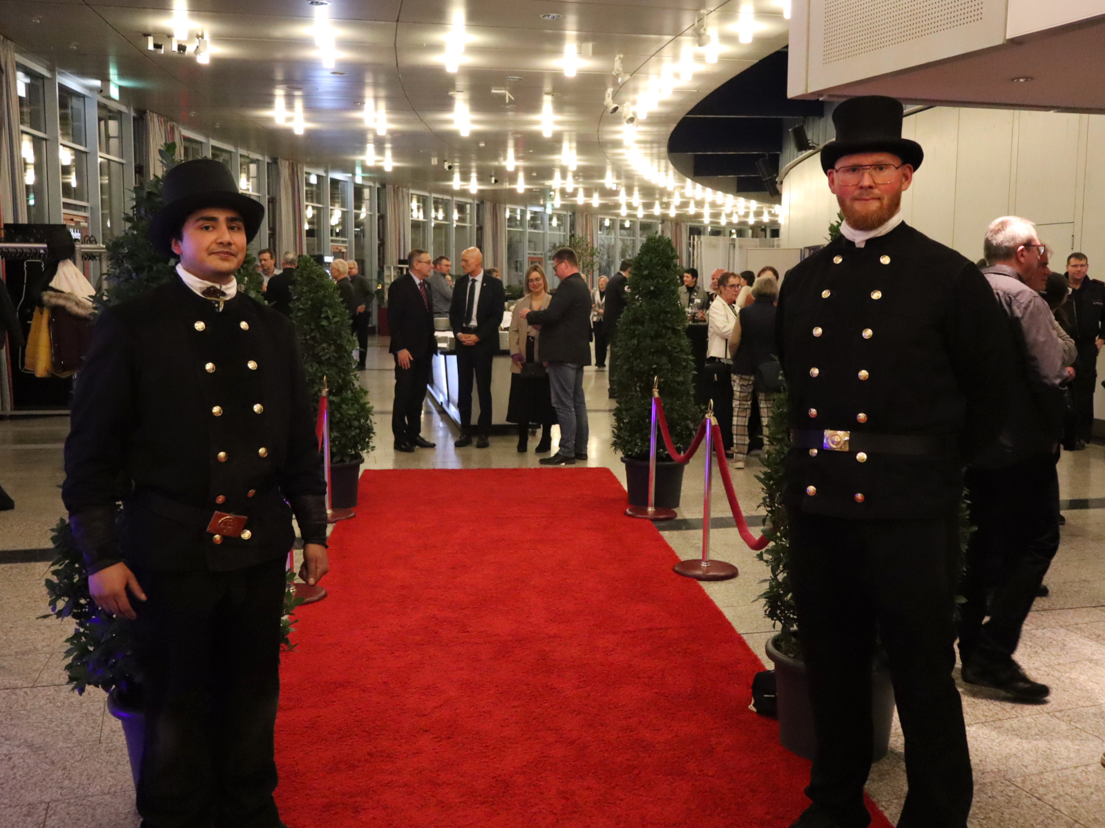 Zwei Schornsteinfeger stehen am "roten Teppich" und begrüßen die Gäste.