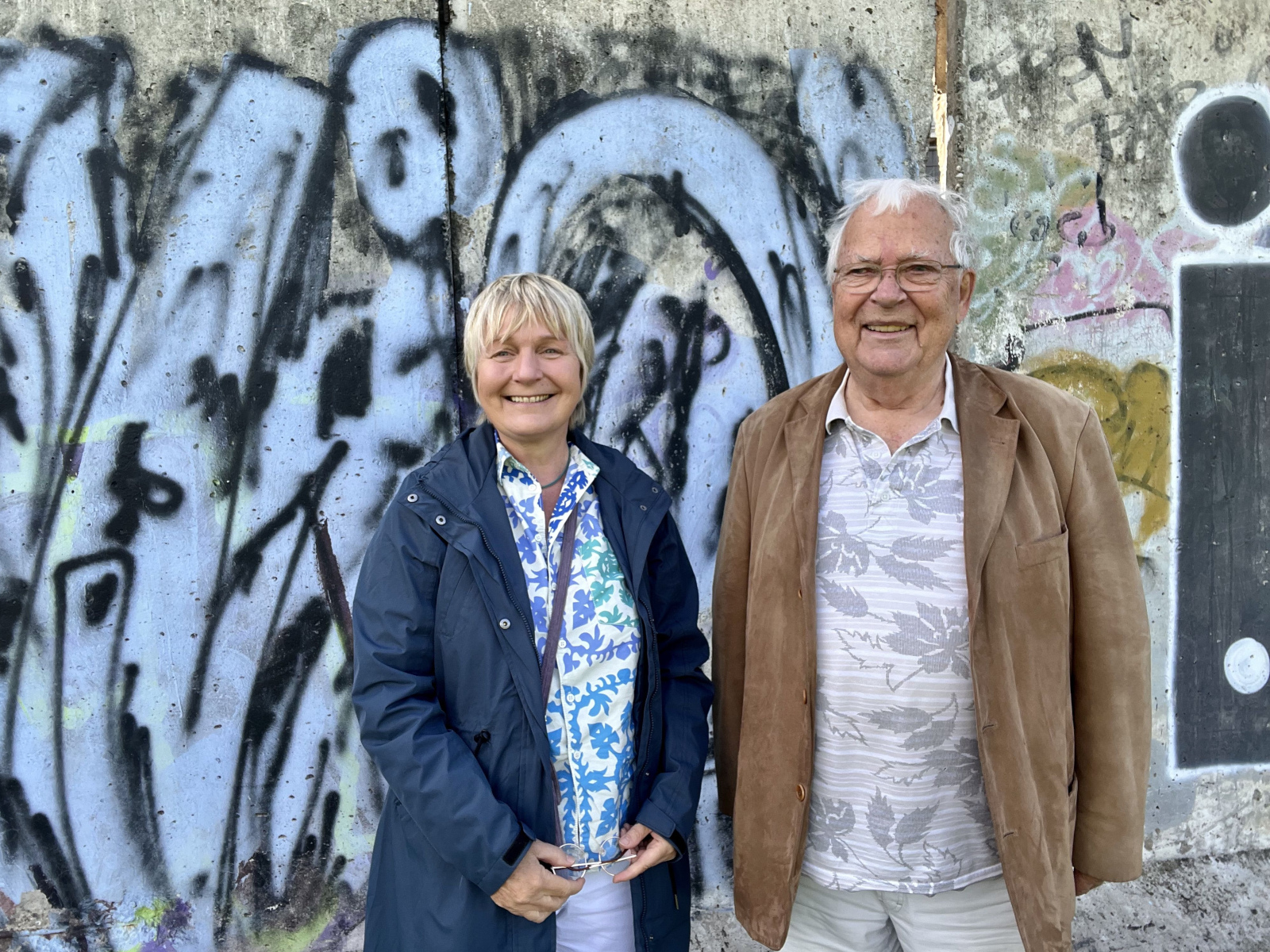Maja Nielsen und Joachim Neumann vor einem Stück der Berliner Mauer.