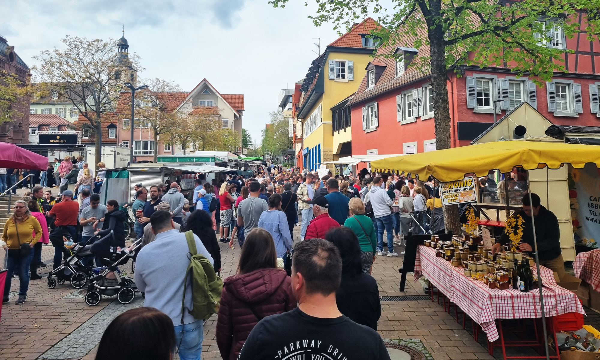 Zahlreiche Menschen laufen durch die Fußgängerzone, entlang von Verkaufsständen.