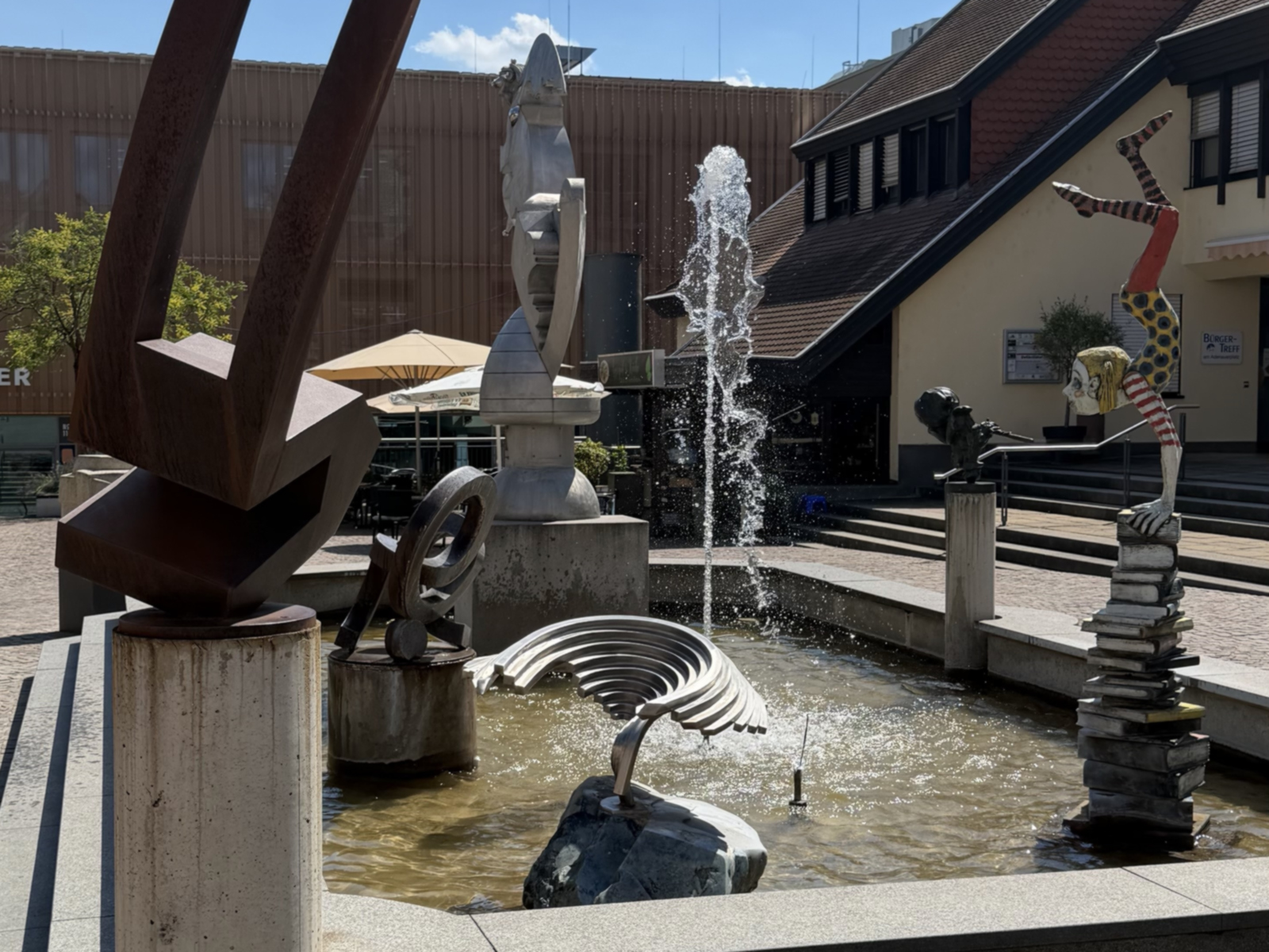 Brunnengalerie mit Wasserfontaine und mehreren Kunstwerken.